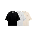 Three t-shirts in black, white, and beige with a logo on a white background